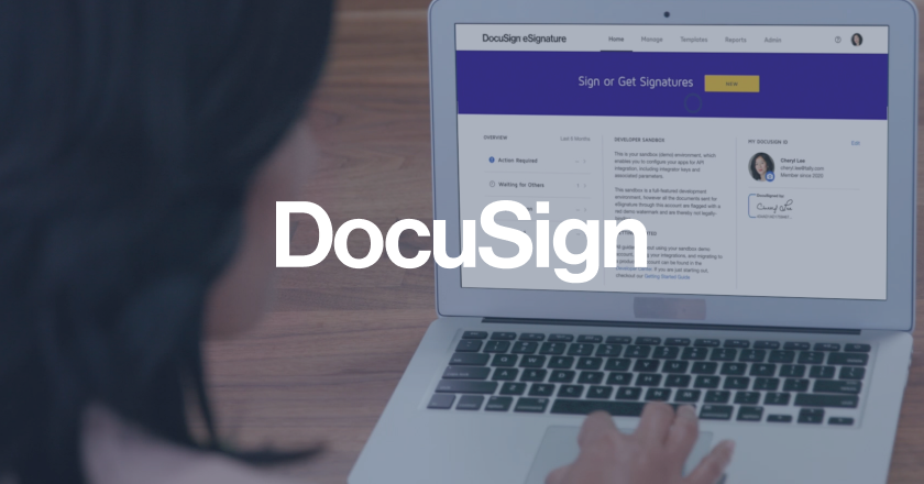 DocuSign logo on top of person typing on a laptop