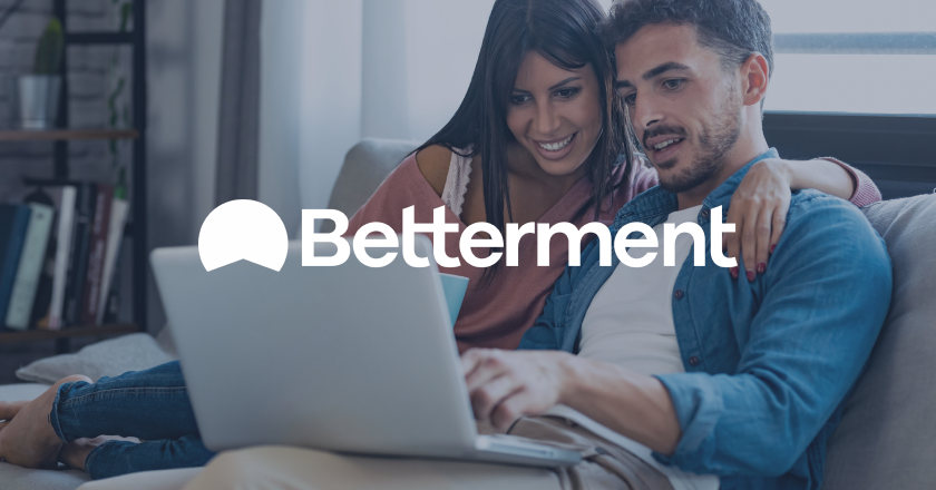 White Betterment logo on top of two people looking at a laptop screen