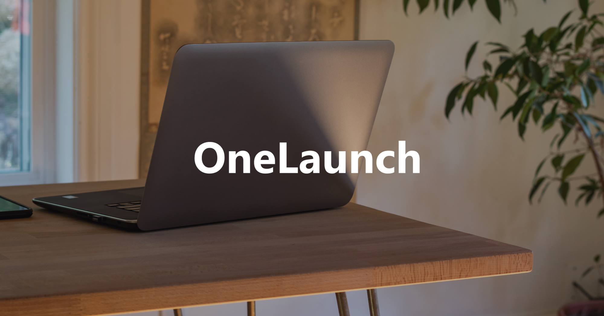 Onelaunch logo on top of laptop on desk